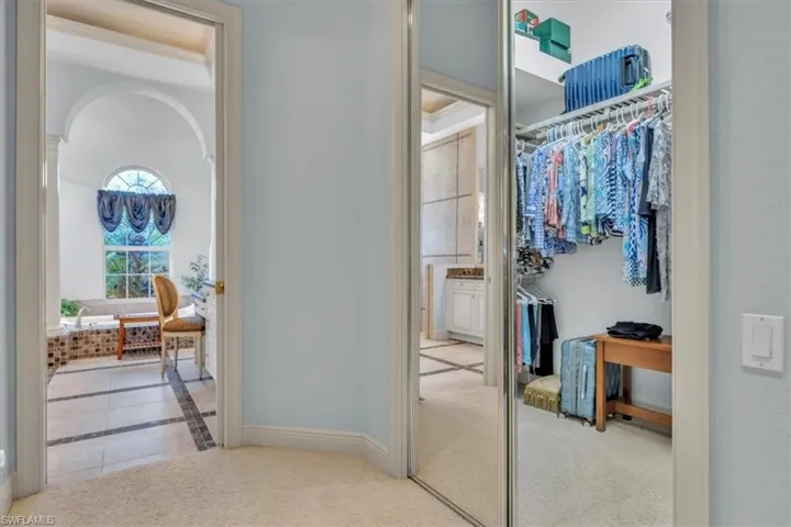 Hall featuring light carpet and light tile patterned floors