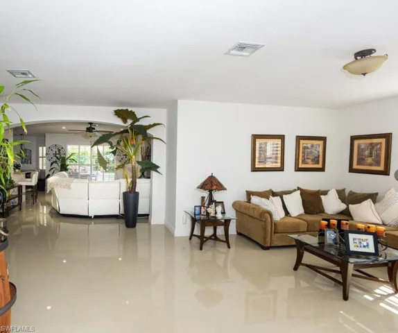 Living room featuring a ceiling fan and light tile patterned floors