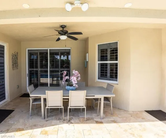 View of patio with outdoor dining space and a ceiling fan
