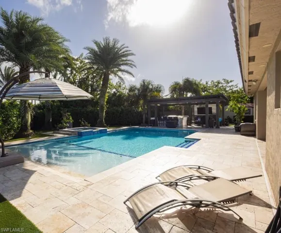 View of pool with a patio area and a pool with connected hot tub