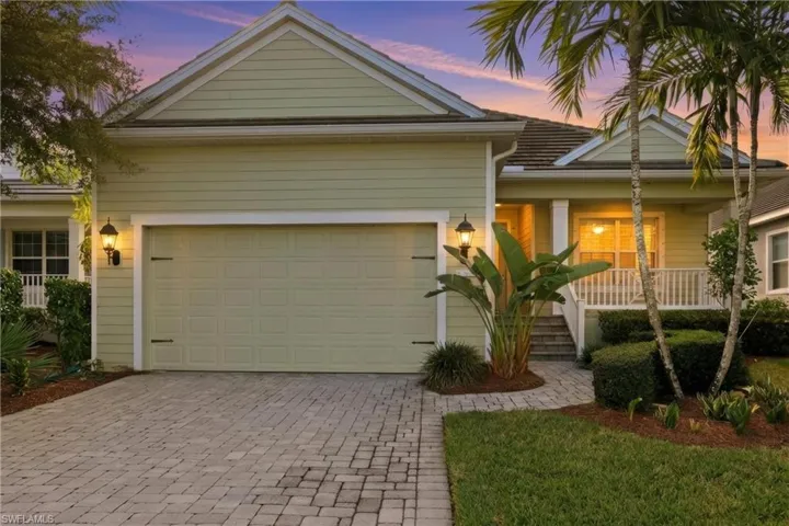 View of front of house with covered porch, decorative driveway, and an attached garage