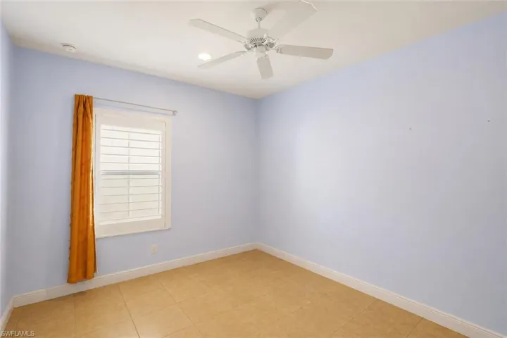 Room featuring tile flooring, a ceiling fan, recessed lighting, and a window with white louvered shutters