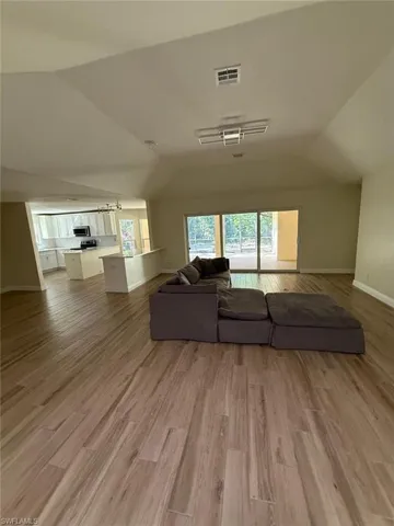 Living room featuring light wood finished floors and vaulted ceiling