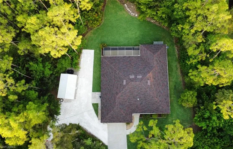 View of subject property with a tree filled landscape