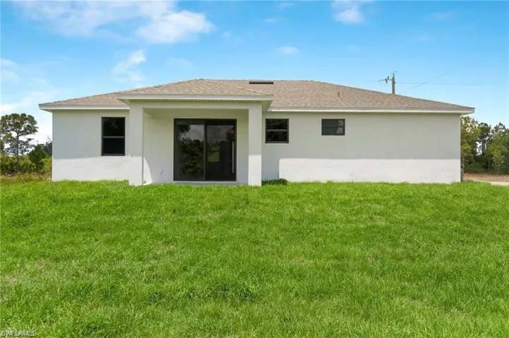 Rear view of property featuring a yard