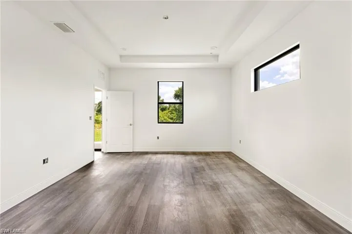 Empty room featuring a raised ceiling and hardwood / wood-style floors