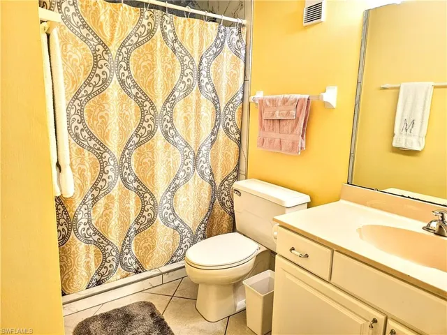 Bathroom featuring tile patterned flooring, vanity, and toilet