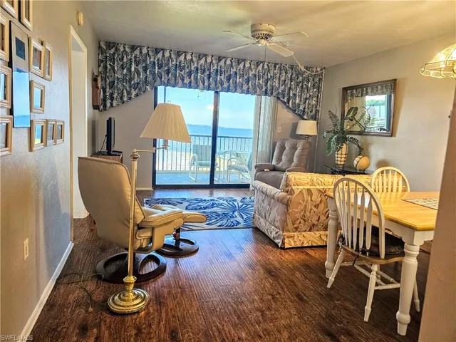 Living room with ceiling fan and hardwood / wood-style floors