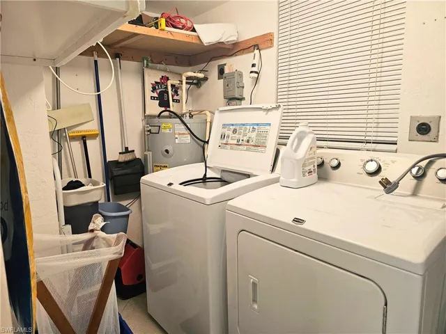 Clothes washing area with washer and clothes dryer and electric water heater