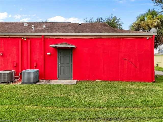 Rear view of property with a yard and roof with shingles