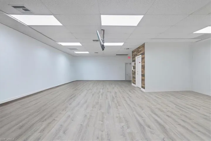 Empty room featuring light wood-style floors and a paneled ceiling