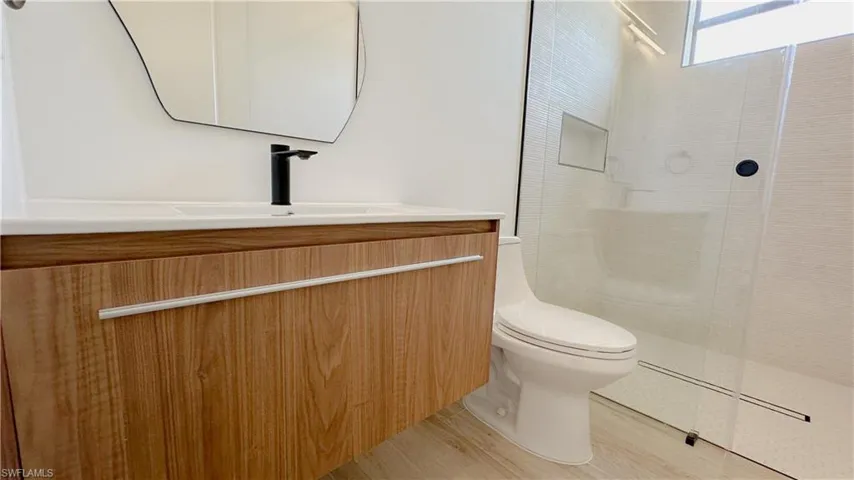 Bathroom featuring vanity, toilet, and walk in shower