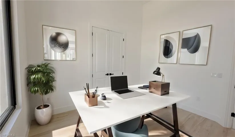 Office with light wood-style floors and baseboards