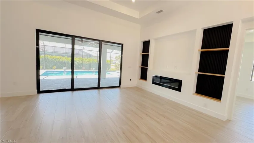 Unfurnished living room with baseboards and light wood-style floors