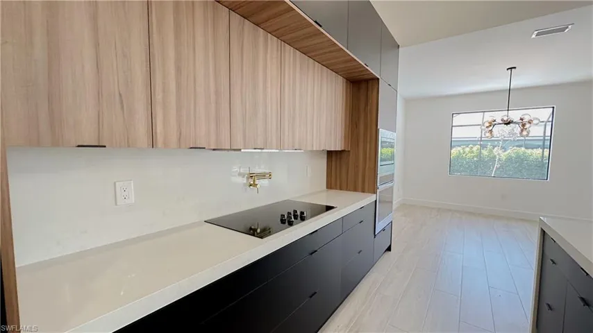 Kitchen featuring visible vents, light countertops, appliances with stainless steel finishes, modern cabinets, and a chandelier