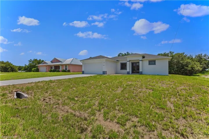 Single story home featuring a garage and a front yard