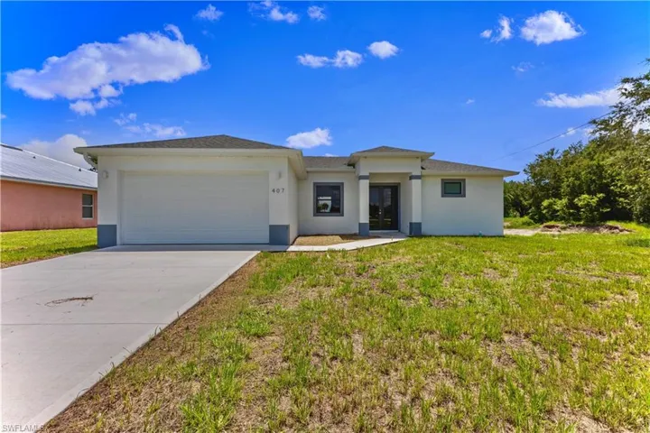 View of front of property featuring a garage and a front yard