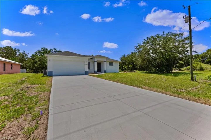 View of front of property featuring a garage and a front lawn