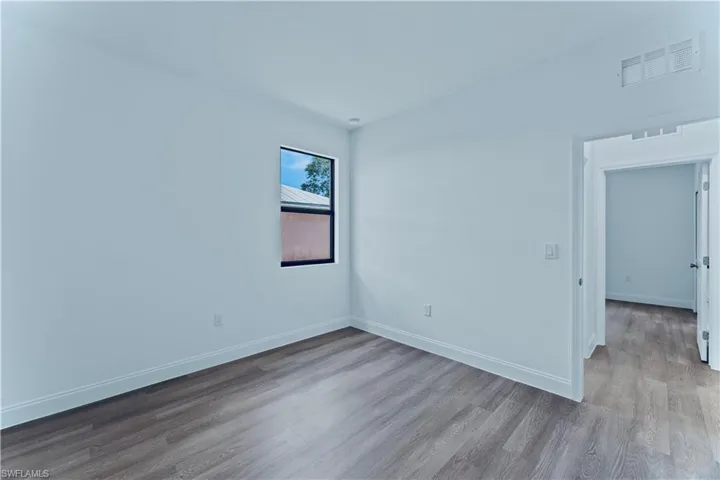 Empty room with hardwood / wood-style flooring