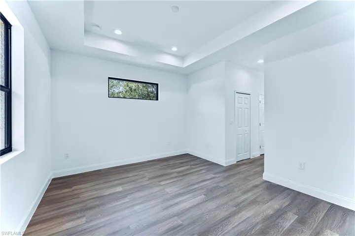 Unfurnished room with hardwood / wood-style floors and a tray ceiling