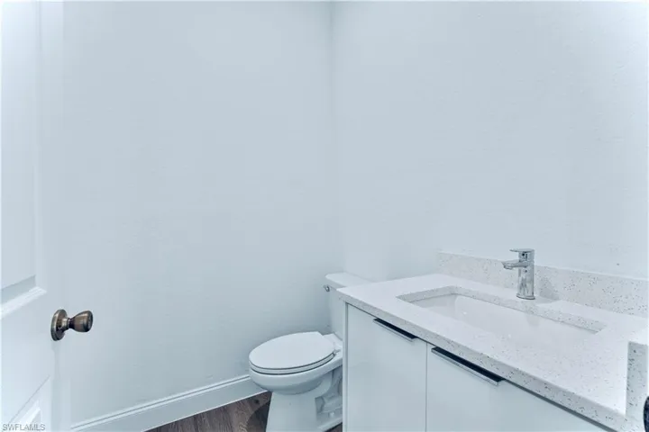 Bathroom with vanity, toilet, and hardwood / wood-style flooring