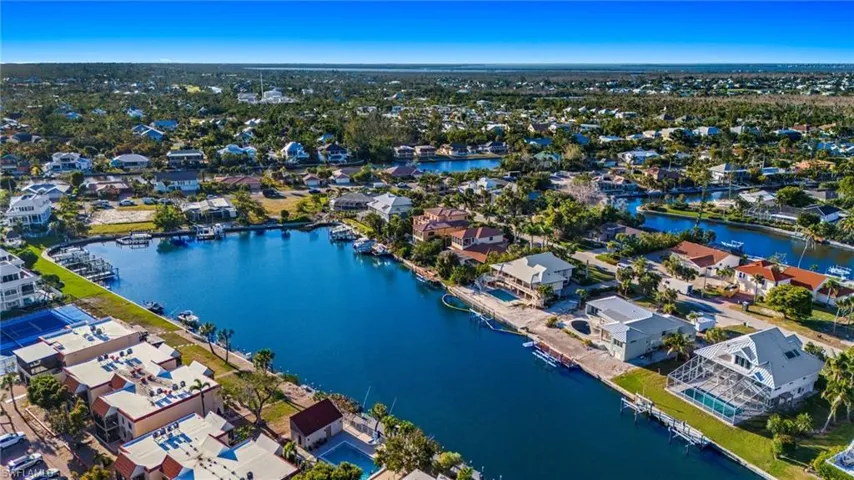 Aerial view of property and surrounding area with nearby suburban area and a nearby body of water