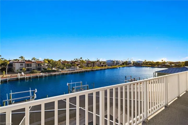 Balcony with a residential view, a water view, boat lift, and a balcony
