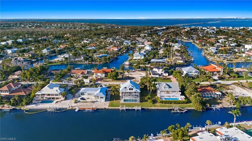 Aerial view of property's location featuring a large body of water and nearby suburban area