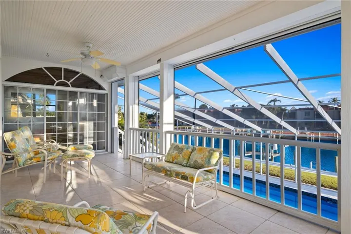 Unfurnished sunroom with a ceiling fan and a water view