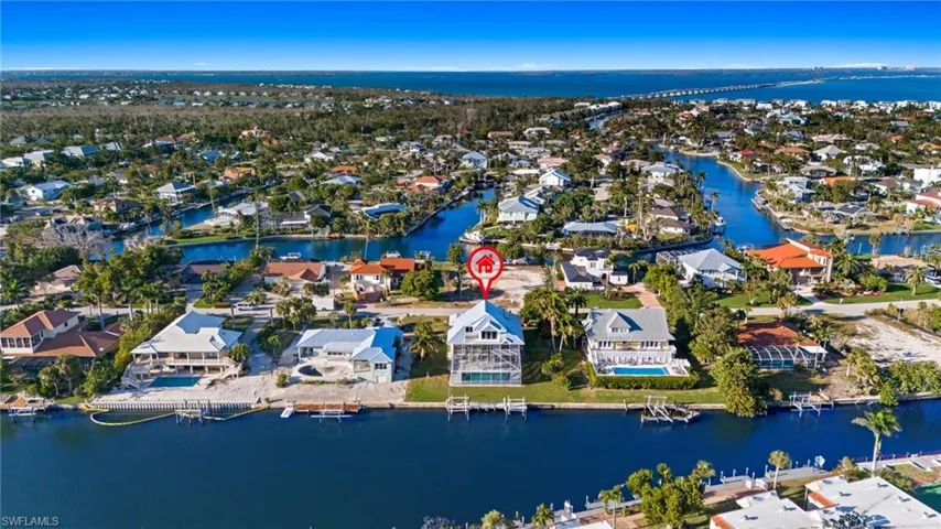 Aerial view of property's location featuring a nearby body of water and nearby suburban area