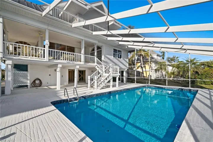 Swimming pool featuring a patio area, a lanai, and a sunroom