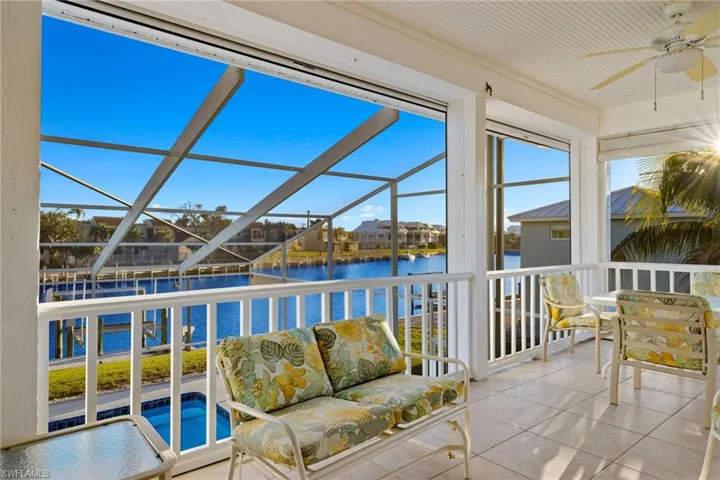 Sunroom / solarium featuring tile patterned floors and a water view