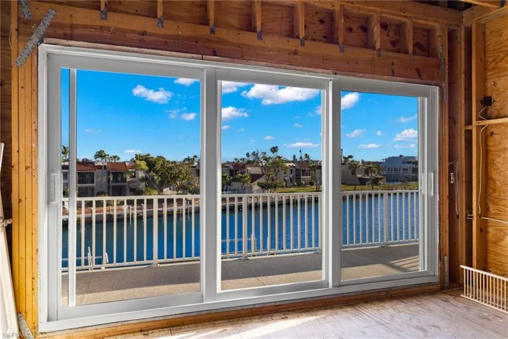 Sliders to outside featuring a water view, a residential view, and healthy amount of natural light