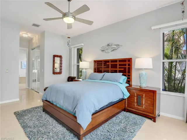 Bedroom featuring connected bathroom, ceiling fan, and light tile patterned floors