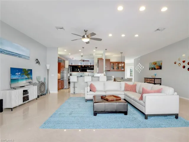 Living room with light tile patterned floors and ceiling fan