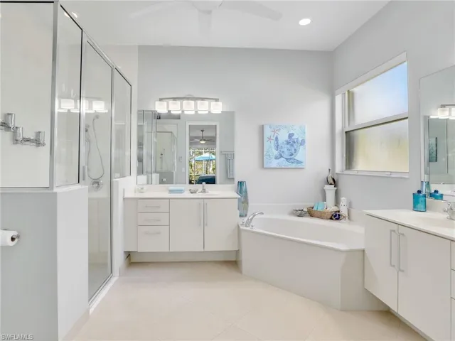 Bathroom featuring tile patterned flooring, shower with separate bathtub, vanity, and ceiling fan