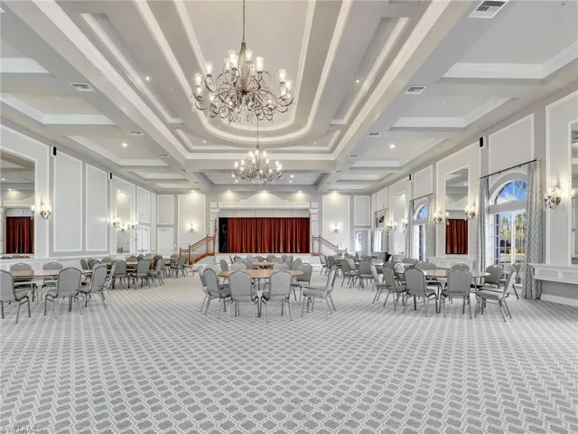 Carpeted dining room featuring beamed ceiling, coffered ceiling, and an inviting chandelier
