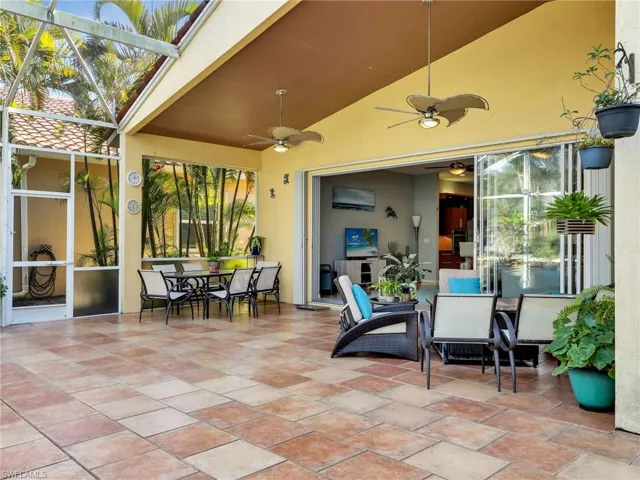 View of patio / terrace with a lanai, a wall mounted AC, and ceiling fan
