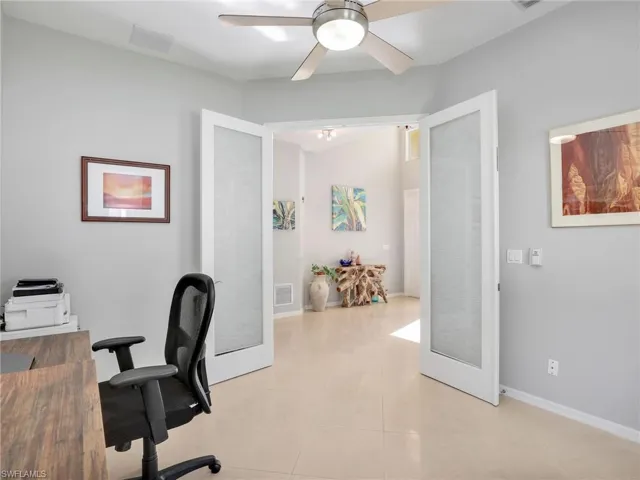 Home office featuring ceiling fan, light tile patterned floors, and french doors