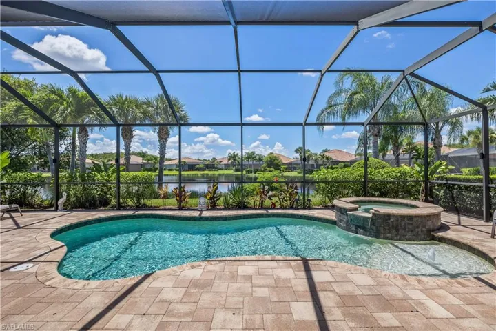 View of swimming pool featuring an in ground hot tub, a lake view, a patio area, and a large lanai