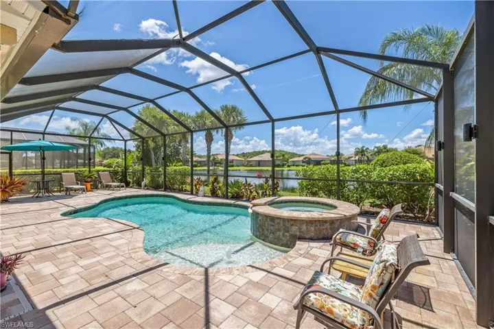View of pool featuring a patio, in-ground hot tub,  screened lanai, with lake view