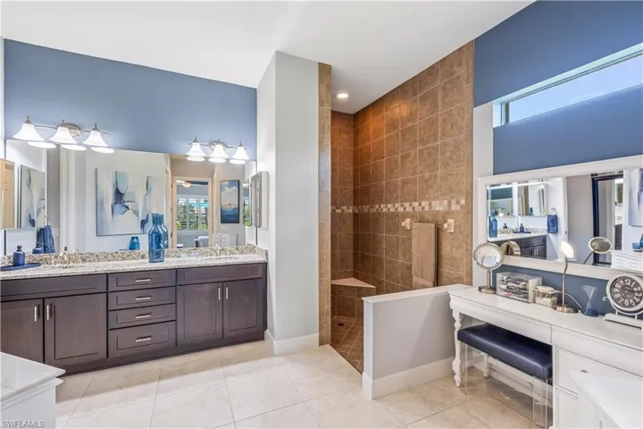 Master Bathroom with dual sink vanity, a tile walk-in shower, and a vanity area