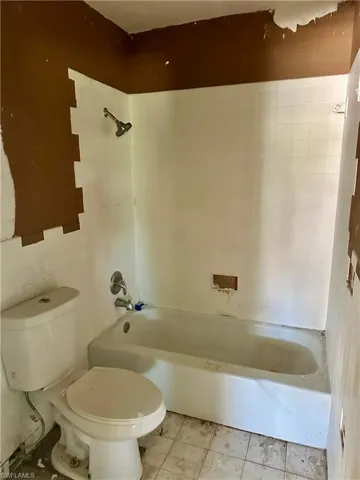Bathroom featuring bathtub / shower combination and light tile patterned flooring