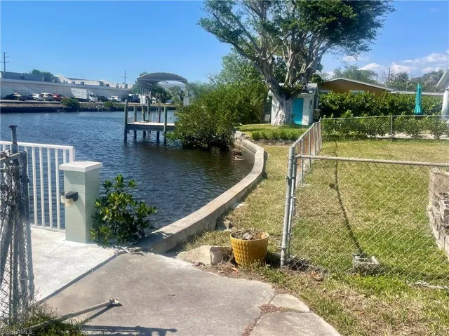 Dock featuring a water view and a gate