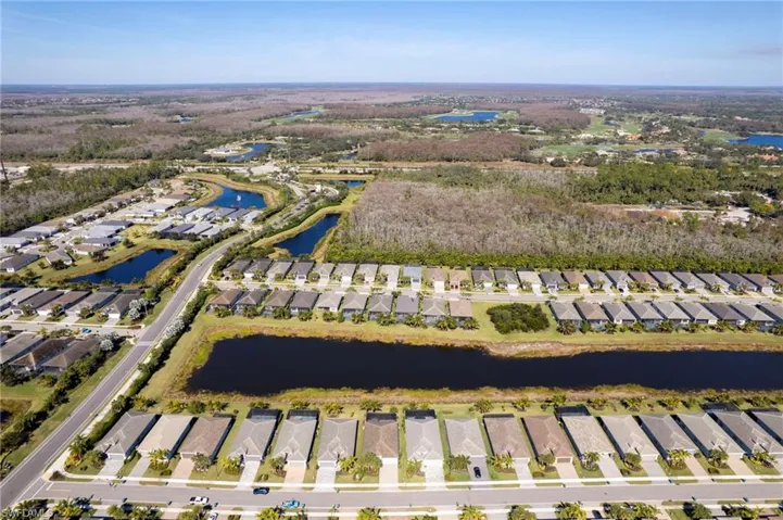 Aerial view of property and surrounding area with nearby suburban area and a large body of water
