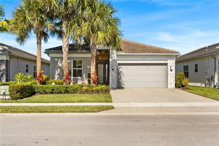 View of front of property with stucco siding, decorative driveway, a garage, covered porch, and a tiled roof
