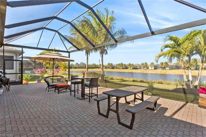 View of patio with glass enclosure, a sunroom, a residential view, and a water view