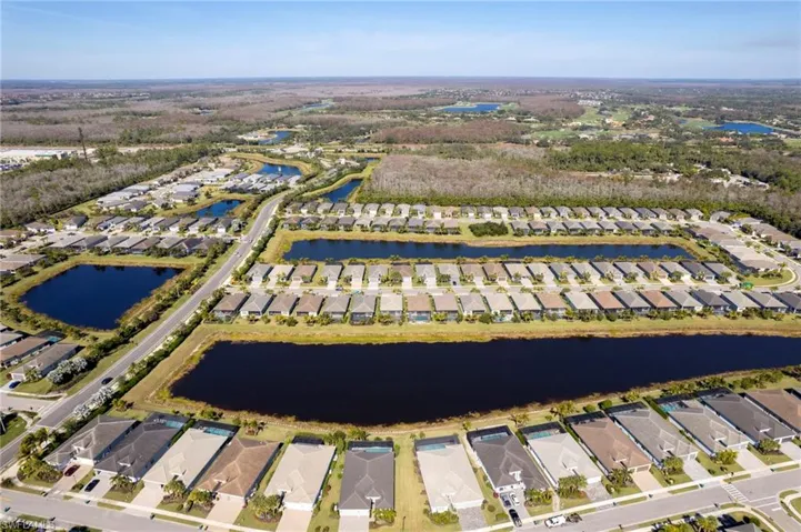 Aerial perspective of suburban area featuring a nearby body of water