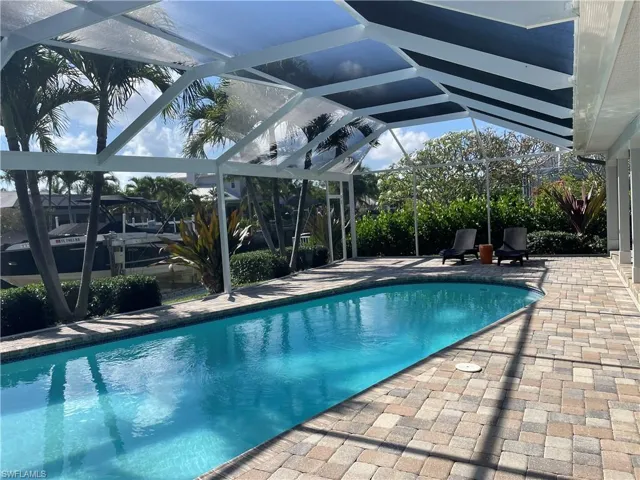 Swimming pool with a patio and glass enclosure