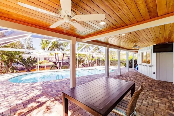 Swimming pool with a patio, a lanai, and outdoor dining area